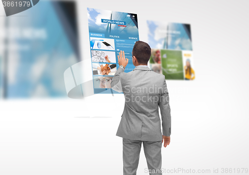 Image of man with virtual projection of business news