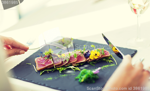 Image of close up of woman eating salad at restaurant