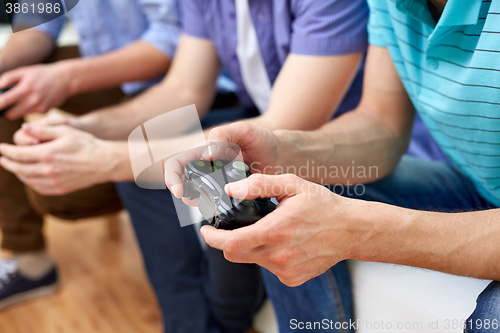 Image of close up of friends playing video games at home