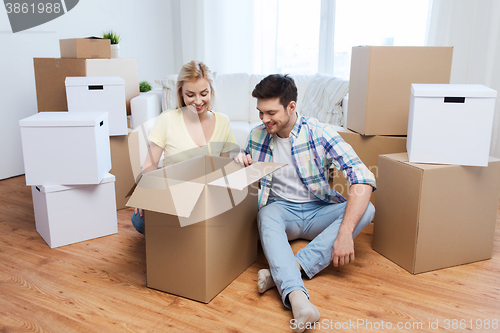 Image of smiling couple with big boxes moving to new home