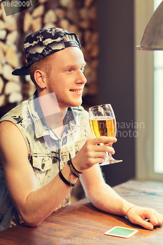Image of happy man drinking beer at bar or pub