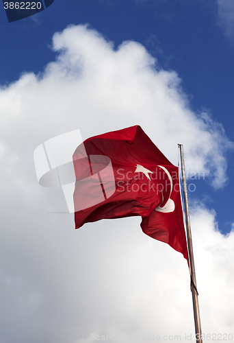 Image of Turkish flag and blue sky with clouds