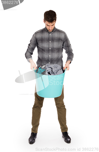 Image of Full length portrait of a young man holding a laundry basket