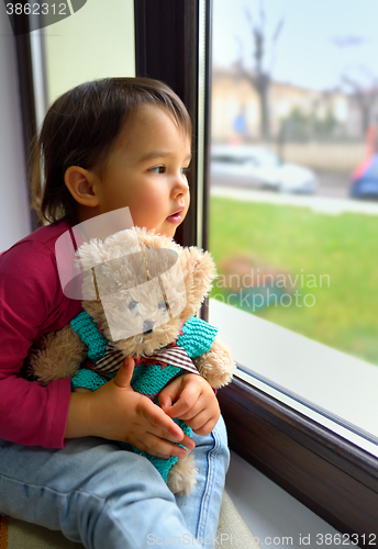 Image of Little girl looking out the window