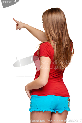 Image of Back view of a young female pointing at copy space