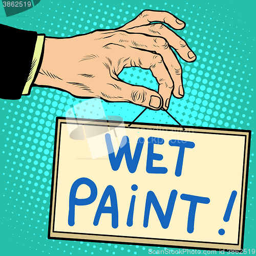 Image of Hand holding a sign wet paint 