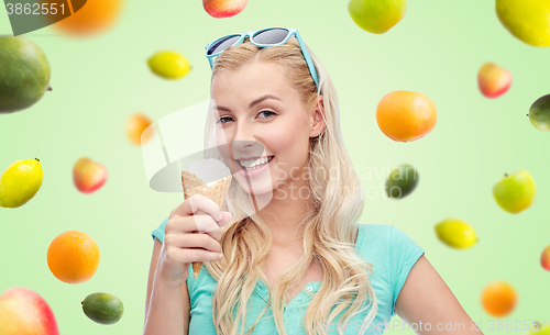 Image of happy young woman in sunglasses eating ice cream