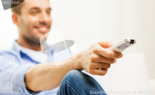 Image of close up of man with tv remote control at home