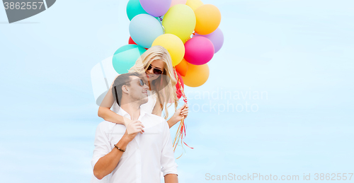 Image of couple with colorful balloons at seaside