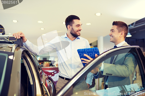 Image of happy man with car dealer in auto show or salon