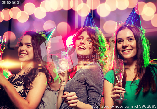 Image of smiling friends with glasses of champagne in club