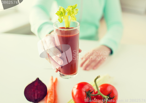 Image of close up of woman hands with juice and vegetables