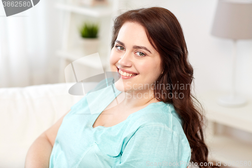 Image of happy young plus size woman at home