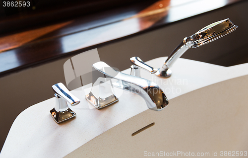 Image of close up of bath tap and shower at bathroom