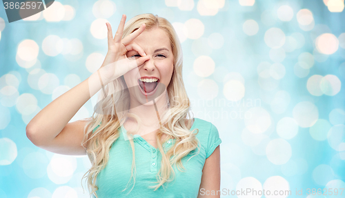 Image of young woman making ok hand gesture