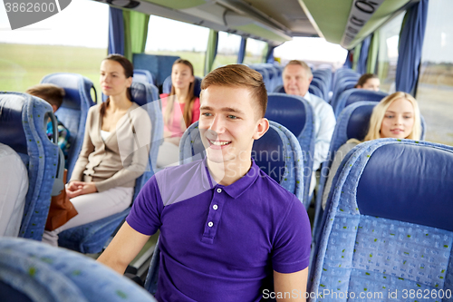 Image of happy young man sitting in travel bus or train