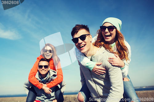 Image of happy friends in shades having fun outdoors