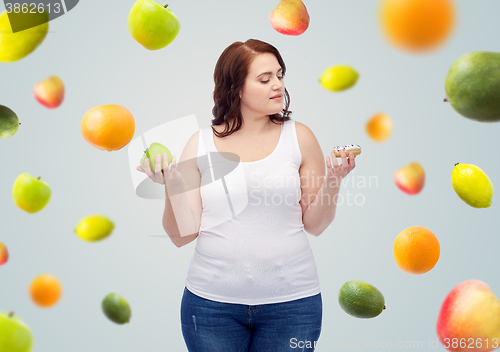 Image of young plus size woman choosing apple or cookie