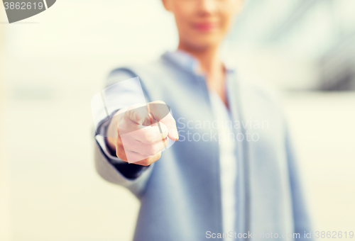 Image of young smiling businesswoman over office building