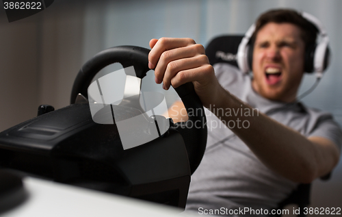 Image of close up of man playing car racing video game