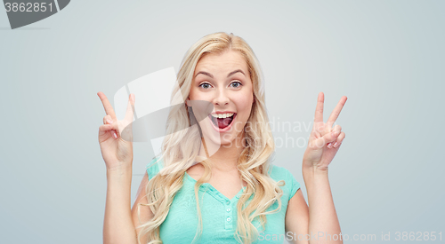 Image of smiling young woman or teenage girl showing peace