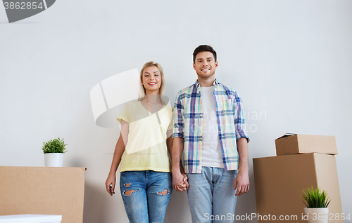 Image of smiling couple with big boxes moving to new home