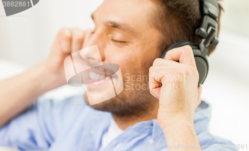 Image of smiling young man in headphones at home