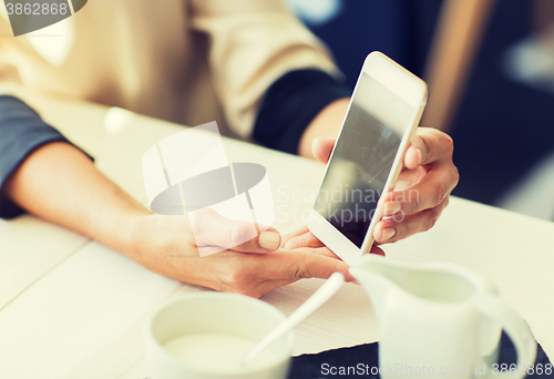 Image of close up of women with smartphone at restaurant