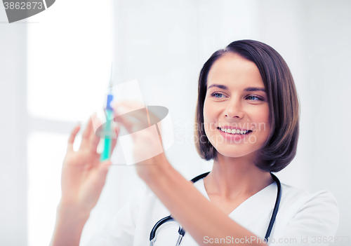 Image of female doctor holding syringe with injection