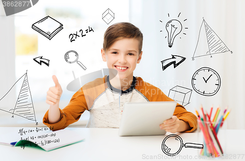 Image of happy boy with tablet pc showing thumbs up at home