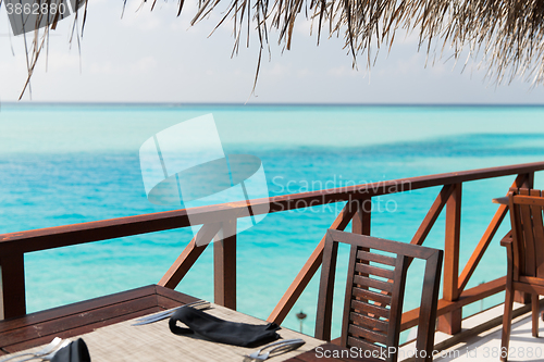 Image of outdoor restaurant terrace with furniture over sea