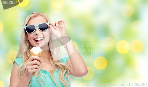 Image of happy young woman in sunglasses eating ice cream