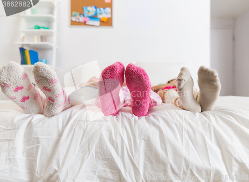 Image of close up of women feet in socks on bed at home