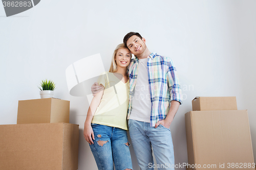 Image of smiling couple with big boxes moving to new home