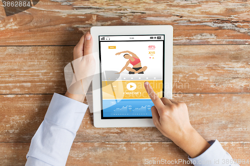 Image of close up of hands with sport app on tablet pc