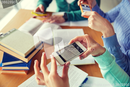 Image of students with smartphones making cheat sheets