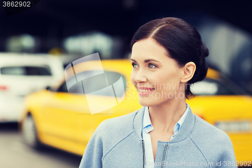 Image of smiling woman over taxi station or city street