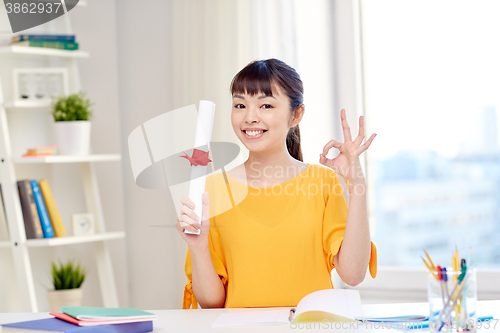 Image of happy asian woman student with diploma at home