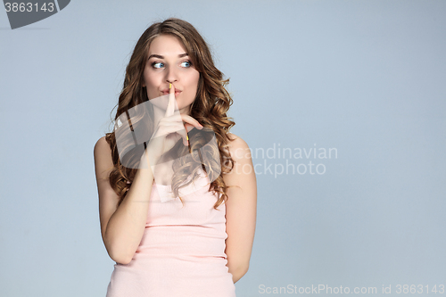 Image of Secret woman. Female showing hand silence sign 