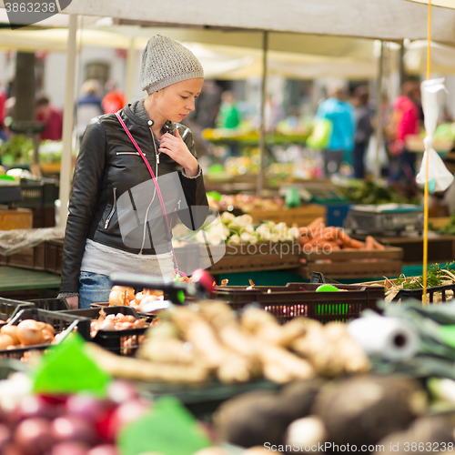 Image of Woman buying vegetable at local food market. 