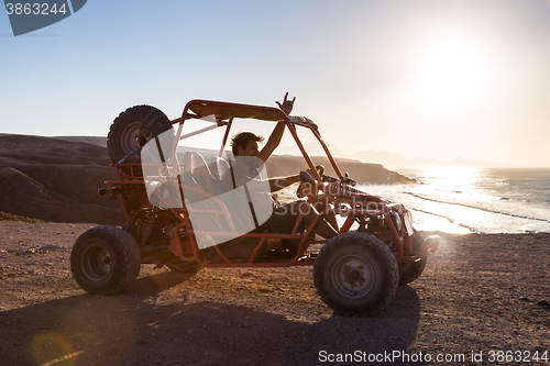 Image of Man driving quadbike in sunset.