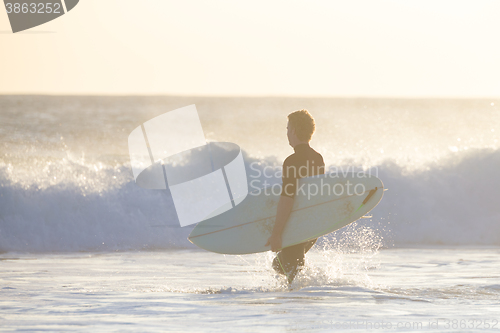 Image of Surfers on beach with surfboard.