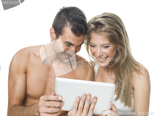 Image of attractive couple watching things in a tablet