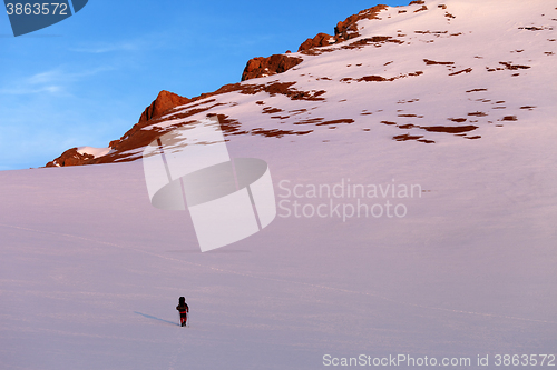 Image of Hiker in sunrise snowy mountains