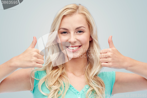 Image of happy woman or teenage girl showing thumbs up