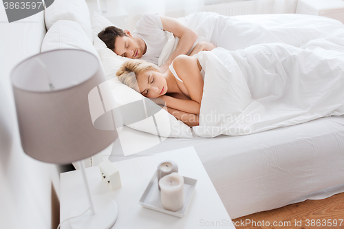 Image of happy couple sleeping in bed at home