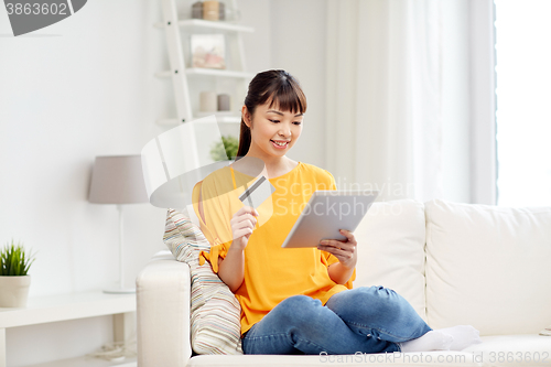 Image of happy asian woman with tablet pc and credit card