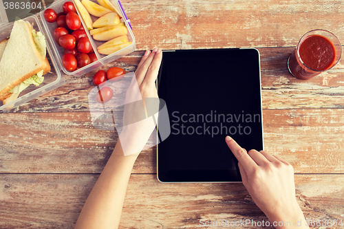 Image of close up of woman with tablet pc food on table