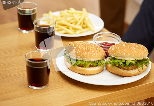 Image of close up of fast food and drinks on table at home