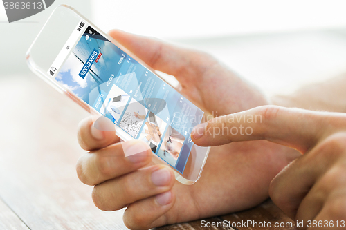 Image of close up of male hand with world news smartphone
